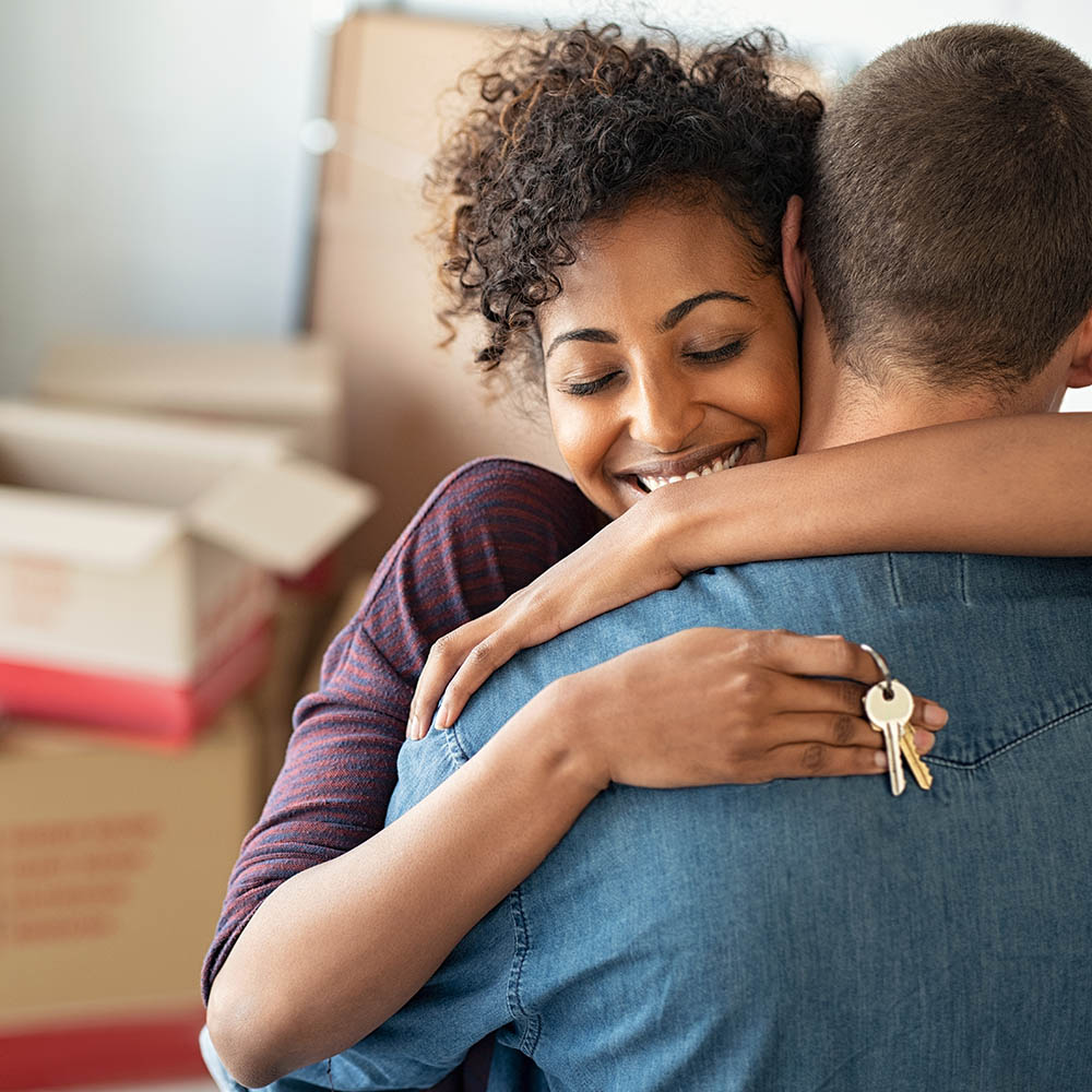 Woman hugging man and holding home keys