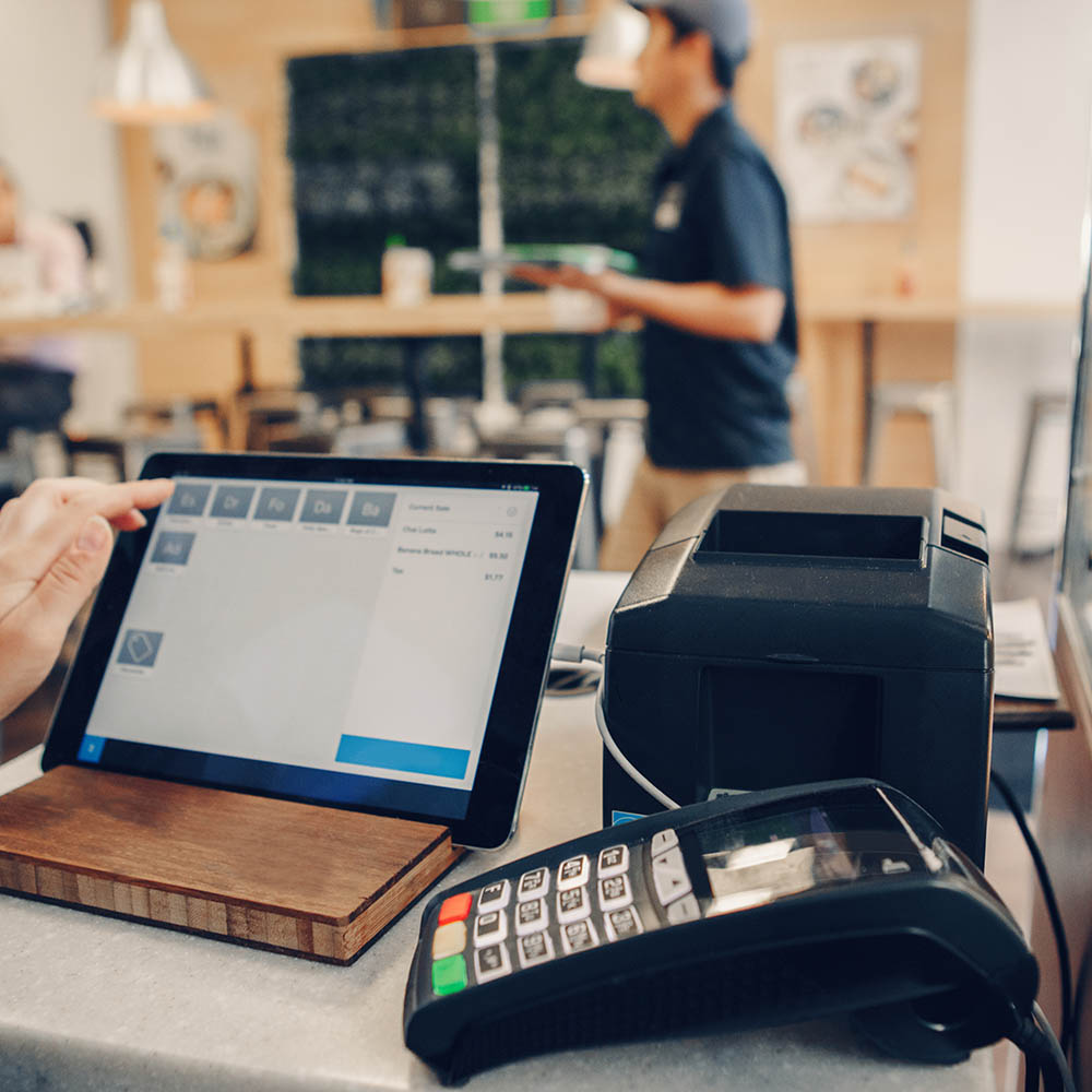 Closeup shot of caucasian cashier hands. Seller using touch pad