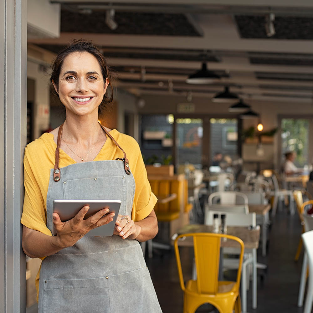 Small business owner at entrance looking at camera