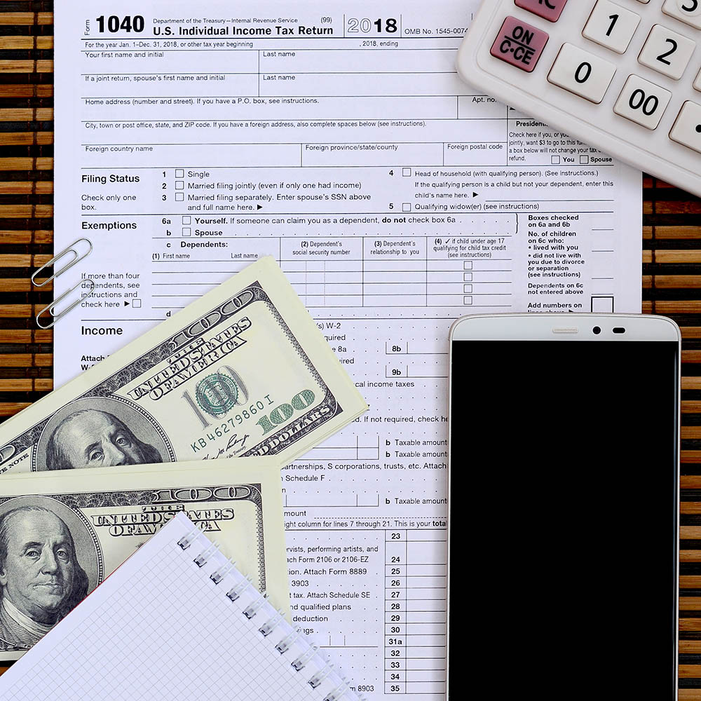 Composition of items lying on the 1040 tax form. Dollar bills, c